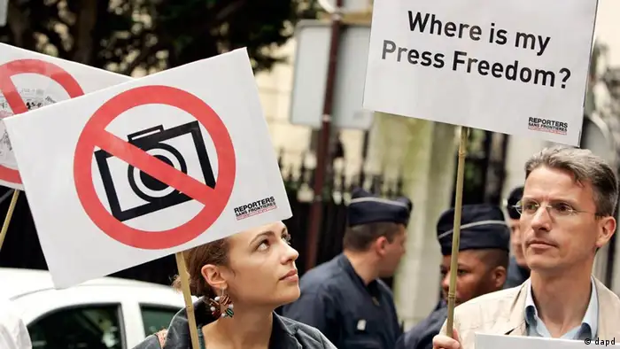 Members of French media watchdog Reporters Without Borders gather near the Iranian embassy in Paris, during a demonstration for press freedom in Iran, Thursday June 18, 2009 in Paris. Two riot policemen are seen standing guard rear center. (ddp images/AP Photo/Francois Mori)