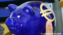 ARCHIV - Illustration - Ein überdimensionaler Euro wird am 15.08.2007 vor der Europäischen Zentralbank (EZB) in Frankfurt an ein Sparschwein gehalten. Das neue Hilfspaket für Griechenland wird einen Umfang von 109 Milliarden Euro haben. Das geht aus der Abschlusserklärung des Euro-Krisengipfels vom Donnerstag (21.07.2011) in Brüssel hervor. Der Beitrag der Banken wird mit 37 Milliarden Euro angegeben. Foto: Boris Roessler dpa +++(c) dpa - Bildfunk+++