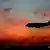 An aircaft descending at sunset