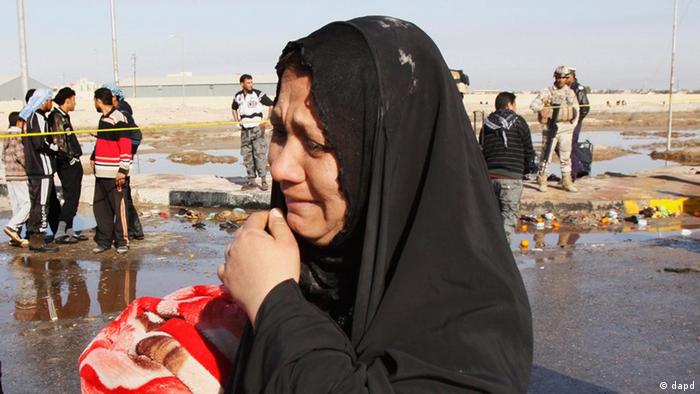A woman cries as security forces and local people inspect the scene of the bomb attack