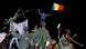A protester waves a flag and shouts slogans from the top of a statue the University Square in Bucharest A protester waves a flag and shouts slogans from the top of a statue the University Square in Bucharest