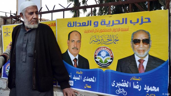 Ein Ägypter schaut sich das Wahlplakat der Freiheits- und Gerechtigkeitspartei der Muslimbrüder an (Foto: dapd)