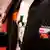 Ein Rechtsextremist in Lederjacke, auf die ein Sticker genäht ist, der das Deutsche Reich in den Grenzen von 1937 zeigt. Mit der rechten Hand schultert der Neonazi einen Baseballschläger. (Foto: Oliver Berg / dpa)