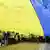 Люди несут огромный флаг Украины