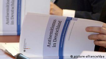 Menschen blättern im Bericht zu Antisemitismus in Deutschland (Foto: dpa)