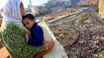 An Egyptian mother hugs her child as she looks down from a balcony at thousands of Egyptian protesters gathered at Tahrir Square in Cairo, Egypt in January 2011 Copyright: Amr Nabil, File/AP/dapd