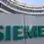 Der Schriftzug des Technologiekonzerns Siemens ist auf einer Tafel und auf dem Gebäude der Deutschlandzentrale der Siemens in München (Oberbayern) zu sehen. (Foto: Andreas Gebert dpa)
