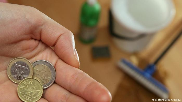 Eine Putzfrau hält in ihrer Hand den Stundenlohn von 3,20 Euro (Foto: dpa)