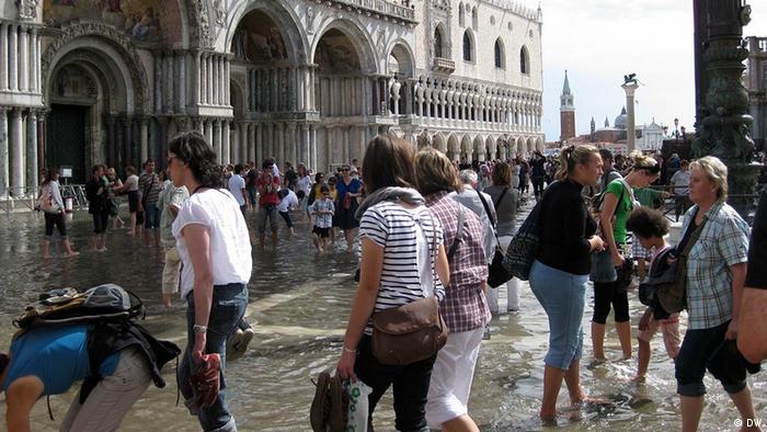 Tourists caught by high tide in front of St. Mark’s Basilica.