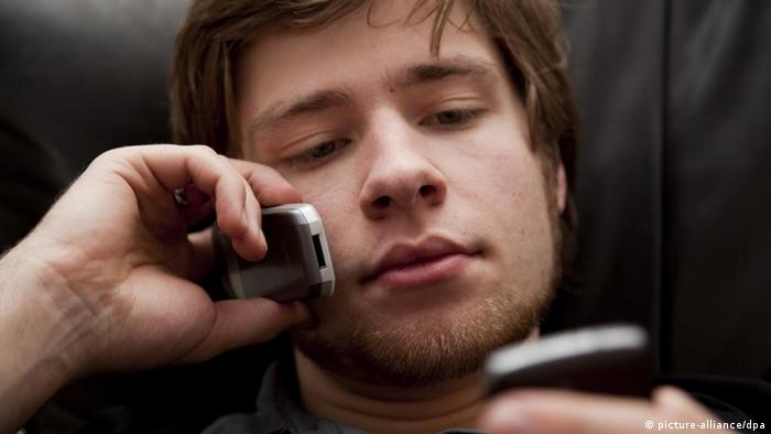 Ein junger Mann spricht am Handy, während er mit seinem Smartphone im Internet surft Der Jugendliche Lukas telefoniert mit einem Handy und surft gleichzeitig mit dem anderen Handy. Aufgenommen am 04.03.2009. Foto: Maximilian Schönherr +++(c) dpa - Report+++
