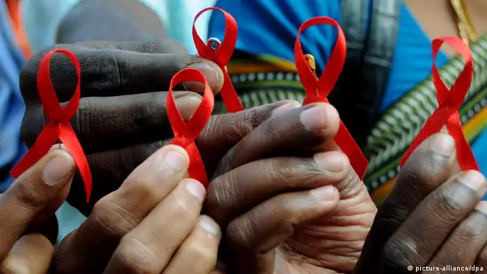 ARCHIV - Indische Aktivisten halten am Welt-Aids-Tag am 01.12.2009 in Bangalore im Süden von Indien die Rote Schleife in den Händen. Die Rote Schleife ist das weltweite Symbol der Solidarität mit HIV-Infizierten und Aidskranken. Laut UNAIDS - der Aids-Organisation der Vereinten Nationen - haben sich seit dem Ausbruch der Pandemie vor fast 30 Jahren rund 60 Millionen Menschen mit dem Virus infiziert, 25 Millionen starben an der Immunschwäche. Vom 18. bis 23. Juli findet in Wien die XVIII.Weltaidskonferenz (AIDS 2010) statt, der weltweit größte internationale Kongress zum Thema HIV/AIDS. EPA/JAGADEESH (zu dpa-Hintergrund HIV/AIDS vom 12.07.2010) +++(c) dpa - Bildfunk+++