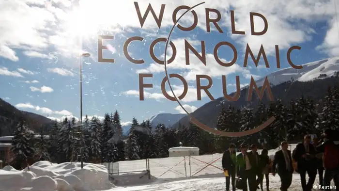 Visitors are reflected in window of the congress center, venue of the World Economic Forum (WEF) in Davos, January 26, 2012. REUTERS/Arnd Wiegmann (SWITZERLAND - Tags: POLITICS BUSINESS)