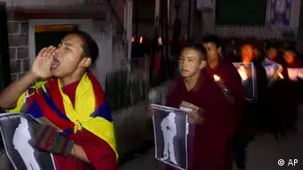 a Tibetan Buddhist monk shouts as he and others hold pictures of Tibetans they claim were allegedly shot by Chinese security forces earlier this week, during a candlelight vigil in Dharamsala, India, Wednesday. Jan. 25, 2012. Deadly clashes between ethnic Tibetans and Chinese security forces have spread to a second area in southwestern China, the government and an overseas activist group said Wednesday. (Foto:Angus McDonald/AP/dapd)