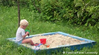 Ein kleiner Junge spielt im Sandkasten