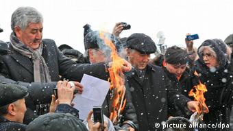 Amirzhan Kosanov (L), a leader of the National Social Democratic Party, burning papers at a rally against the results of the January 15 parliamentary elections. (Photo ITAR-TASS/ Anatoly Ustinenko)