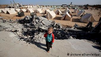 Palestinian boy walks in a tent area erected in the east of Jabaliya refugee camp in the northern Gaza Strip