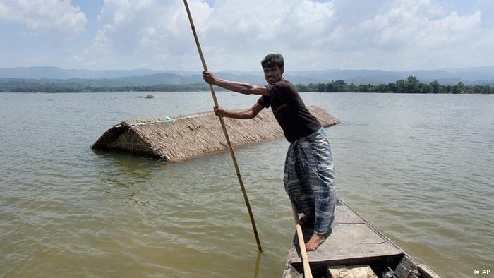 A man rows a country boat near his submerged home at Amlighat (photo: AP Photo/Anupam Nath)