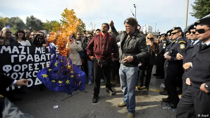 Anti-austerity protesters burn a European Union flag before a military parade in the northern Greek port city of Thessaloniki, Friday, Oct. 28, 2011. Thousands of anti-austerity protesters in the city forced the cancellation Friday's annual military parade commemorating Greece's entry into World War II. The demonstrators heckled Greek President Karolos Papoulias and other attending officials, calling Papoulias a traitor. (Foto:Nikolas Giakoumidis/AP/dapd)