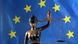 A statue of Justitia, the Roman god of justice, taken in front of an EU flag A statue of Justitia, the Roman god of justice, taken in front of an EU flag