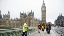 A worker spreads grit onto the pavement on Westminster Bridge in front of the Houses of Parliament, in central London February 5, 2012. Heavy snow fell in some areas of Britain overnight, causing road closures and flight cancellations, and the Met Office warned of icy conditions, local media reported. REUTERS/John Voos (BRITAIN - Tags: CITYSPACE ENVIRONMENT SOCIETY)