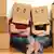 A man and woman with moving boxes on their heads