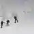 Three skiiers on a very snowy slope