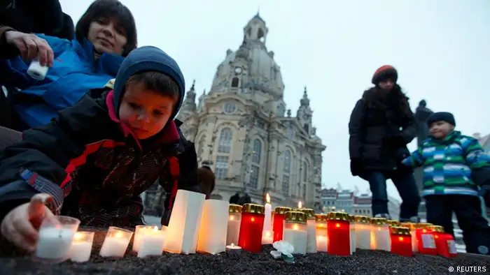Menschen zünden vor der Frauenkirche Kerzen an um gegen Neonazi-Aufmarsch zu protestieren
