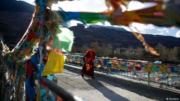 A Tibetan Buddhist nun from the Ganden Jangchup Choeling nunnery crosses a bridge near the town of Daofu, Sichuan province, in this November 13, 2011 file photo. An 18-year-old Tibetan nun died after setting herself on fire in protest at Chinese rule in Tibet, activists said on February 12, 2012, adding to a fast growing list of self-immolations in ethnically Tibetan areas of China. Chinese army troops moved in after Tenzin Choedon set herself alight at the Mamae convent in China's southwestern Sichuan province, said Kanyag Tsering, a monk in Dharamsala, India, where the Tibetan government-in-exile is based. REUTERS/Carlos Barria/Files (CHINA - Tags: POLITICS CIVIL UNREST RELIGION)