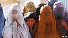 FILE: A Young girl peers out from a row of women veiled in the traditional Afgan Burqa covering at a Red Cross distribution center in Kabul, Afganistan in this November 13, 1996 file photo taken by Madrid bureau Associated Press photographer Santiago Lyon. Lyon, 31, won France's Bayeux Prize for War Correspondants Saturday, October 18, 1997, for his photographs of the 1996 takeover of Kabul, Afghanistan, by the Taliban religious militia. (AP Photo/Santiago Lyon/File)