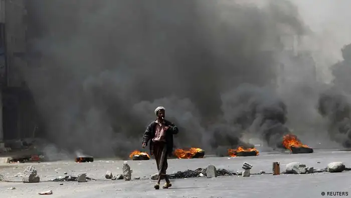 A man walks past tyres set on fire by followers of a southern separatist group, calling for a boycott to Yemen's presidential elections, to block a road in the southern port city of Aden February 21, 2012. Yemenis began voting on Tuesday to replace President Ali Abdullah Saleh in an election many hope will give Yemen a chance to rebuild the country shattered by a year-long struggle that had pushed Yemen to the brink of civil war. Vice President Abd-Rabbu Mansour Hadi stands uncontested as a consensus candidate. REUTERS/Khaled Abdullah (YEMEN - Tags: POLITICS ELECTIONS CIVIL UNREST TPX IMAGES OF THE DAY)