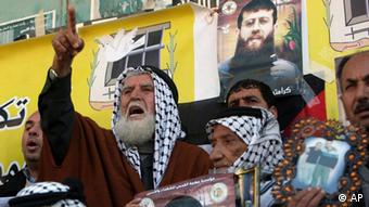 Palestinians demonstrating, holding banners with pictures of Adnan. Photo:Mohammed Ballas/AP/dapd