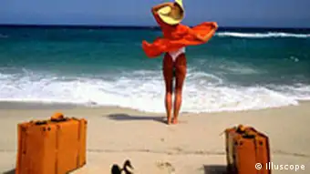 Frau mit Koffer am Strand