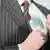 Symbolbild zur Korruption: Ein Mann im Anzug steckt mehrere Hundert Euro Scheine in seine Tasche. Eingestellt am 13.9.2011. © granata68 - Fotolia.com Korrupter Geschäftsmann © granata68 #28961612