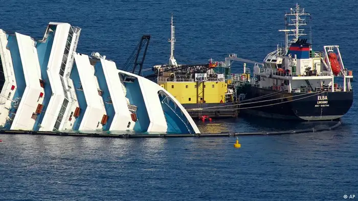 Ongoing operations to remove fuel from the half sunken hulk of the luxury ship Costa Concordia a month after it ran aground are seen outside the port of Isola del Giglio island in Tuscany, Italy, Monday, Feb. 13, 2012. (Foto:Giorgio Fanciulli/AP/dapd)