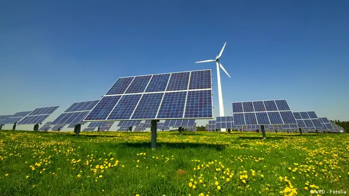 Solaranlage und Windrad auf grüner Wiese