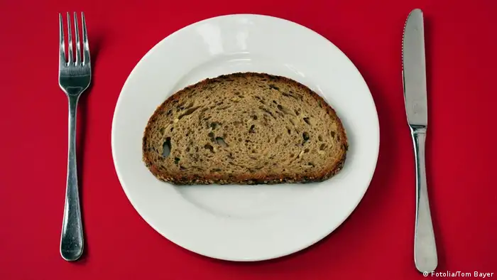 Scheibe Brot auf Teller mit Besteck