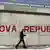 A pedestrian walks by a graffiti reading 'Kosova Republic!'