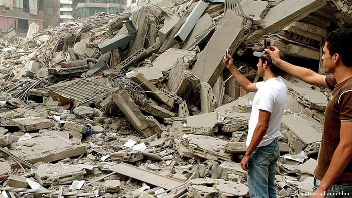 Lebanese citizens take pictures with mobile phones of debris in Haret Hreik district in southern Beirut after an Israeli missile attack in July 2006.