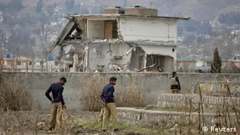Policemen stand guard near the partially demolished compound where al Qaeda leader Osama bin Laden was killed by U.S. special forces last May, in Abbottabad February 26, 2012. Pakistani forces began demolishing the house where Bin Laden was killed by U.S. special forces last May, in an unexplained move carried out in the dark of night. REUTERS/Faisal Mahmood (PAKISTAN - Tags: SOCIETY CONFLICT)