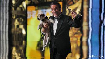 Jean Dujardin carries Uggie the dog after The Artist won the Oscar for Best Picture at the 84th Academy Awards in Hollywood. Copyright: REUTERS/Gary Hershorn