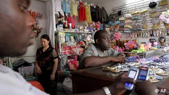 Senegalese shop assistants wait for clients under the watch of the Chinese owner's sister