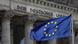 A European flag waving before the German parliament building A European flag waving before the German parliament building