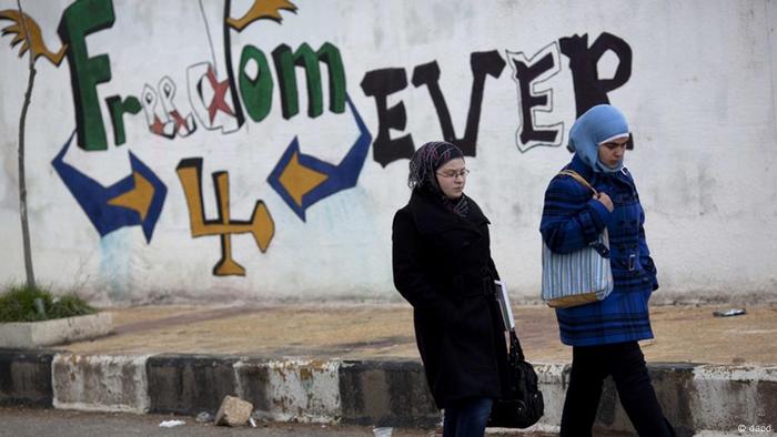 Women walk pass a graffiti that reads Freedom for Ever on the outskirts of Idlib, north Syria, Thursday, March 1, 2012. (Foto:Rodrigo Abd/AP/dapd)