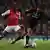 Arsenal's Alex Song, left, and AC Milan's Urby Emanuelson battle for the ball