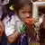 An Indian schoolgirl drinks water from new handpump