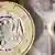 A euro coin in front of an hour-glass