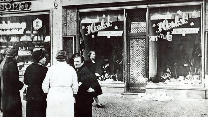  un groupe de personnes se tient devant un magasin appartenant à des Juifs dans une ville allemande sans nom (AP)