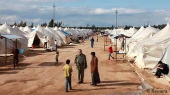 Syrische Flüchtlinge laufen eine Sandstraße im Flüchtlingslager Reyhanli in der Türkei entlang (Foto: REUTERS/Jonathon Burch)
