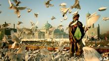 An old man feeds the pigeons near the Shrine of Hazrat Ali on the first day of the Eid al-Fitr Festival in Mazar-e Sharif, northern Afghanistan, Thursday Nov. 3, 2005. The three-day Eid al-Fitr festival marks the end of the Muslim holy fasting month of Ramadan.(AP Photo/Tomas Munita)