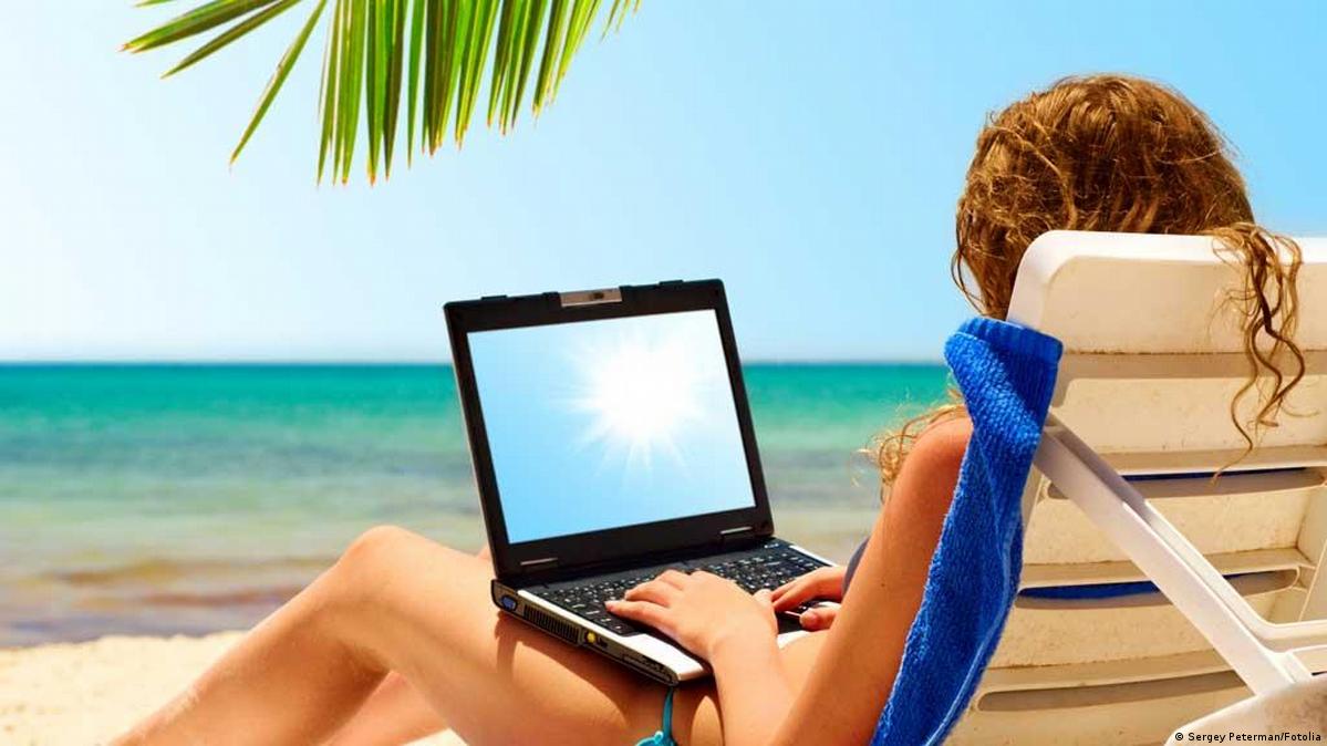 Девушка с ноутбуком на берегу моря
